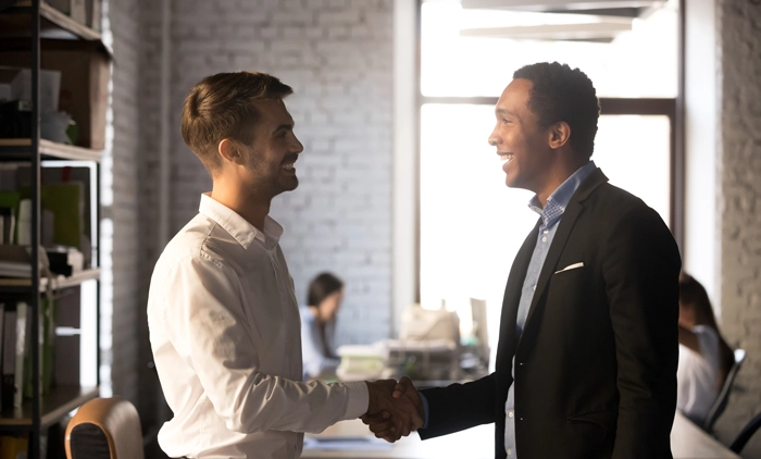 Businessmen shaking hands in office