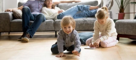 Couple At Home Watching Their Kids Play