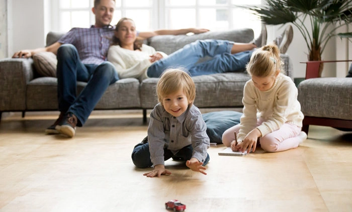 Couple at home watching their kids play