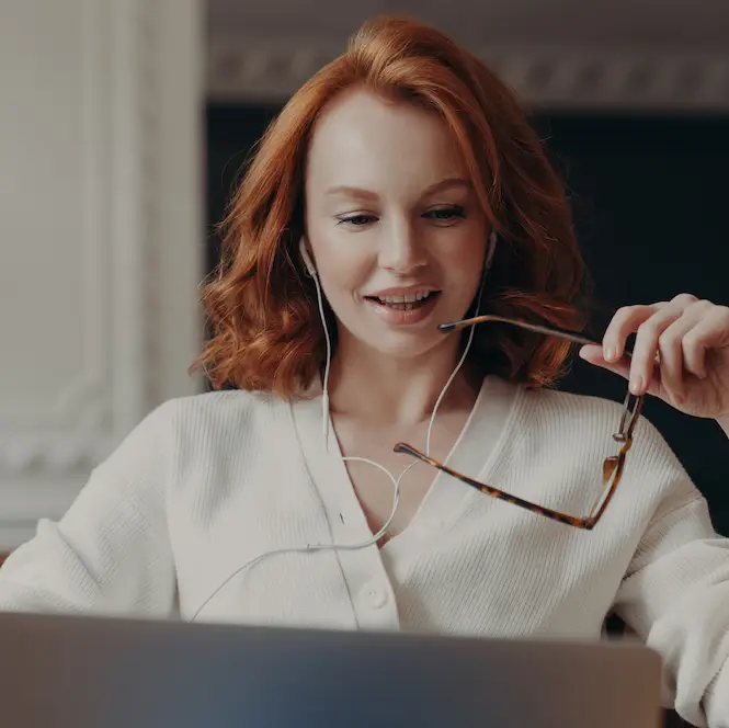 Woman working on laptop while talking on phone